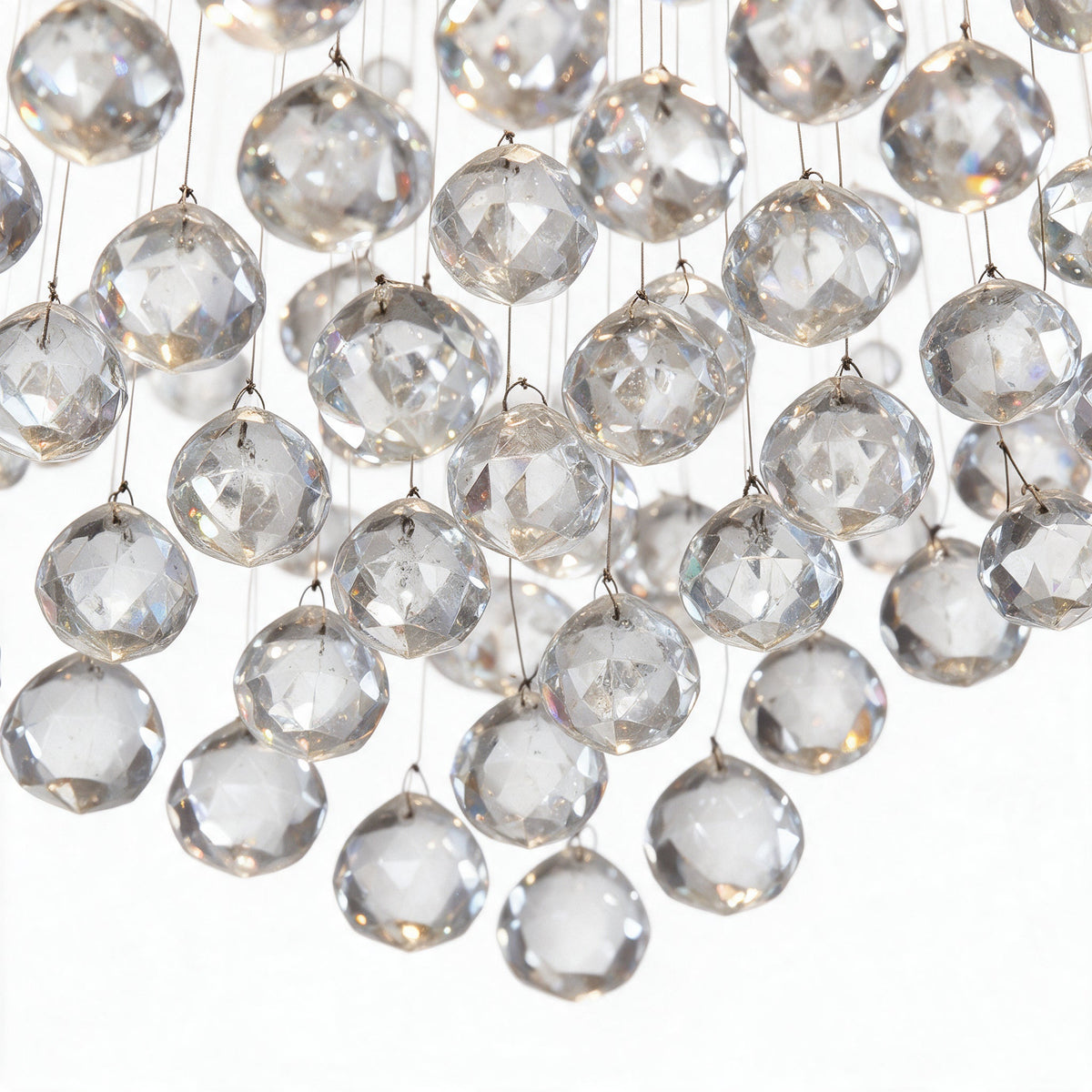 Sillage — détail macro des boules de cristal K9 sur leurs fils d'acier